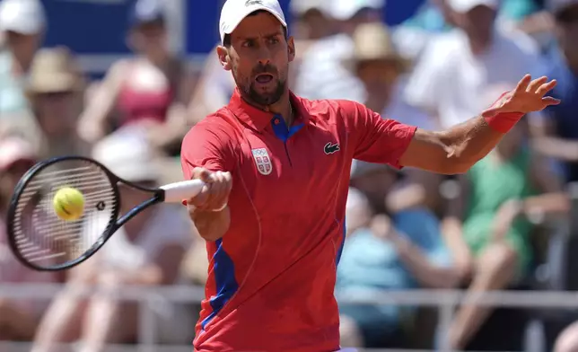 Serbia's Novak Djokovic returns the ball to Spain's Rafael Nadal during their men's singles second round match at the 2024 Summer Olympics, Monday, July 29, 2024, at the Roland Garros stadium in Paris, France. (AP Photo/Andy Wong)