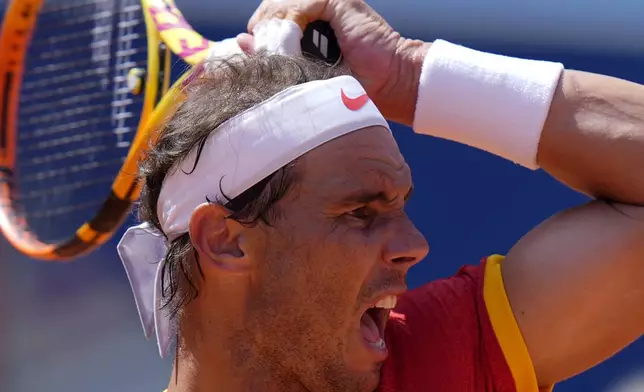 Spain's Rafael Nadal returns the ball to Serbia's Novak Djokovic during their men's singles second round match at the 2024 Summer Olympics, Monday, July 29, 2024, at the Roland Garros stadium in Paris, France. (AP Photo/Andy Wong)