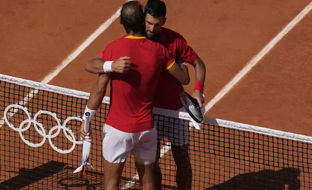 Serbia's Novak Djokovic, right, hugs Spain's Rafael Nadal after their men's singles second round match at the Roland Garros stadium at the 2024 Summer Olympics, Monday, July 29, 2024, in Paris, France. Novak Djokovic dominated rival Rafael Nadal to win 6-1, 6-4 at the Paris Olympics in the second round. (AP Photo/Manu Fernandez)