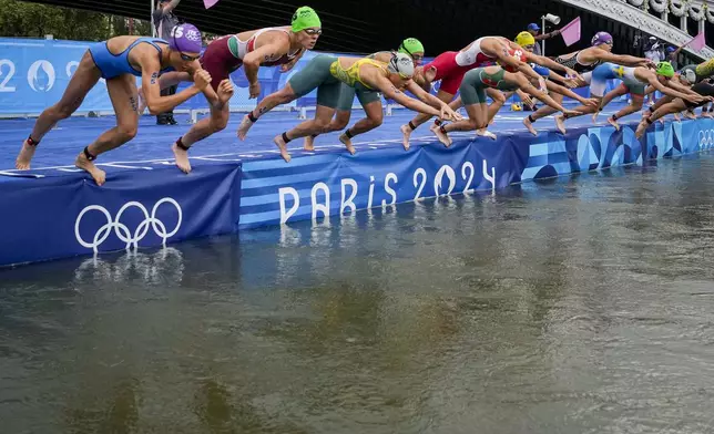 Athletes dive into the water for the start of the women's individual triathlon competition at the 2024 Summer Olympics, Wednesday, July 31, 2024, in Paris, France. (AP Photo/Vadim Ghirda)