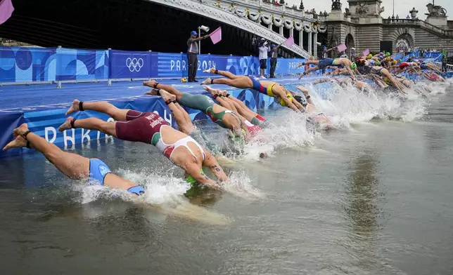 Athletes dive into the water for the start of the women's individual triathlon competition at the 2024 Summer Olympics, Wednesday, July 31, 2024, in Paris, France. (AP Photo/Vadim Ghirda)