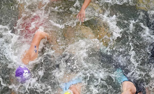 Mexico's Rosa Maria Tapia Vidal (17) and Australia's Natalie Van Coevorden (15) compete in the swim leg of the women's individual triathlon competition at the 2024 Summer Olympics, Wednesday, July 31, 2024, in Paris, France. (AP Photo/David Goldman)