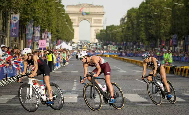 Britain's Beth Potter, left, Hungary's Zsanett Kuttor-Bragmayer, center, and Taylor Spivey, of the United States, right, compete during the bike leg of the women's individual triathlon competition at the 2024 Summer Olympics, Wednesday, July 31, 2024, in Paris, France. (AP Photo/David Goldman)