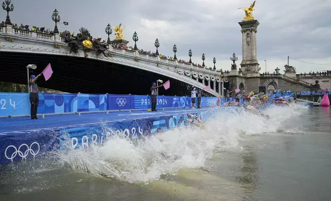 Athletes dive into the water for the start of the women's individual triathlon competition at the 2024 Summer Olympics, Wednesday, July 31, 2024, in Paris, France. (AP Photo/Vadim Ghirda)