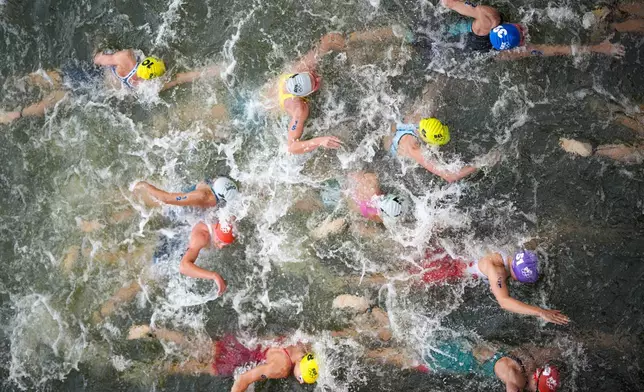 Australia's Natalie Van Coevorden, center, competes in the swim leg of the women's individual triathlon competition at the 2024 Summer Olympics, Wednesday, July 31, 2024, in Paris, France. (AP Photo/David Goldman)