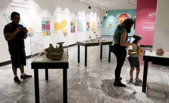 Guests visit the exhibit 'Repatriation and its Impact' at The Parthenon, Tuesday, July 2, 2024, in Nashville, Tenn. The museum is working to repatriate pre-Columbian artifacts back to Mexico. (AP Photo/George Walker IV)