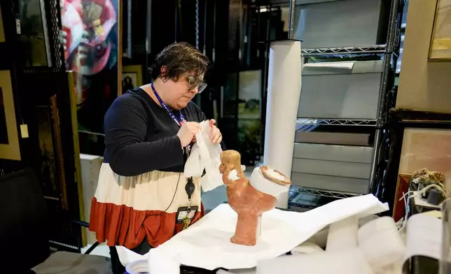 The Parthenon's Registrar and Assistant Curator Bonnie Seymour packs a pre-Columbian artifact from Mexico into boxes Tuesday, July 2, 2024, in Nashville, Tenn. The museum is working to repatriate the items back to Mexico. (AP Photo/George Walker IV)