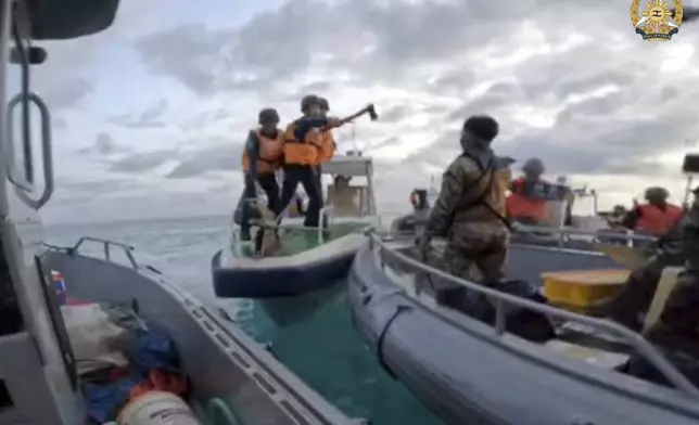 FILE - In this image provided by Armed Forces of the Philippines, a Chinese Coast Guard holds an axe as they approach Philippine troops on a resupply mission in the Second Thomas Shoal at the disputed South China Sea on June 17, 2024. (Armed Forces of the Philippines via AP, File)