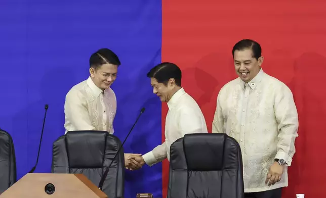 Philippines President Ferdinand Marcos Jr. center, shakes hands with Senate President Francis Escudero, left as House Speaker Martin Romualdez, right,looks on ahead of the State of the Nation Address at the House of Representatives in Quezon City, Philippines, on Monday, July 22, 2024. (AP Photo/ Gerard V. Carreon)