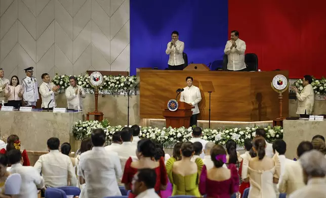 Philippines President Ferdinand Marcos Jr. center, receives a standing ovation during his third State of the Nation Address as Senate President Francis Escudero, top left and House Speaker Martin Romualdez, top right look on at the House of Representatives in Quezon City, Philippines, on Monday, July 22, 2024. (AP Photo/ Gerard V. Carreon)