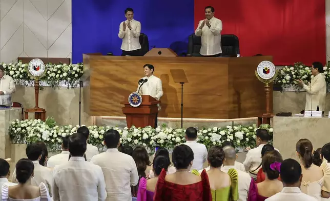 Philippines President Ferdinand Marcos Jr. center, receives a standing ovation during his third State of the Nation Address as Senate President Francis Escudero, top left and House Speaker Martin Romualdez, top right look on at the House of Representatives in Quezon City, Philippines, on Monday, July 22, 2024. (AP Photo/ Gerard V. Carreon)