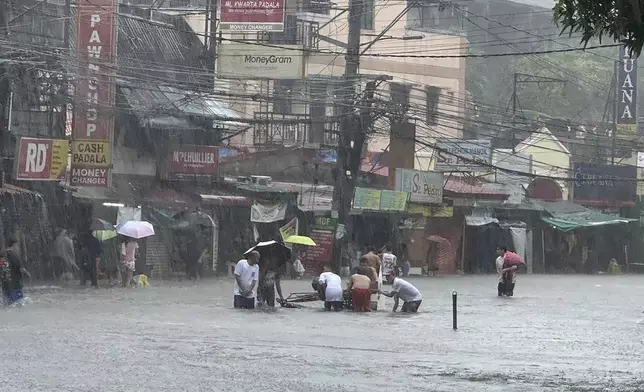 Streets flooded from monsoon rains worsened by offshore typhoon Gaemi on Wednesday, July 24, 2024, in Manila, Philippines. (AP Photo/Joeal Capulitan)