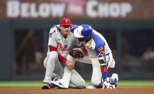 Atlanta Braves' Marcell Ozuna, right, talks to Philadelphia Phillies second baseman Bryson Stott (5) after a play at second base in the fourth inning of a baseball game Saturday, July 6, 2024, in Atlanta. (AP Photo/Brett Davis)