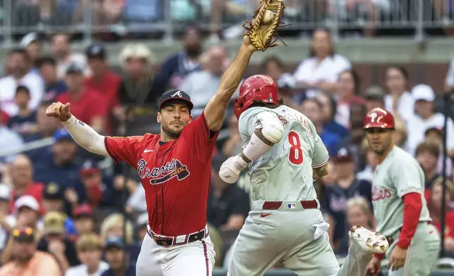 Atlanta Braves first baseman Matt Olson, left, catches the ball before Philadelphia Phillies Nick Castellanos (8) can tag the bag in the first inning of a baseball game Friday, July 5, 2024, in Atlanta. (AP Photo/Jason Allen)