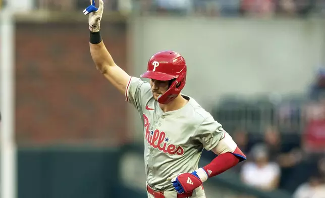 Philadelphia Phillies shortstop Trea Turner waves to the crowd while rounding second base after hitting a home run in the fourth inning of a baseball game against the Atlanta Braves, Friday, July 5, 2024, in Atlanta. (AP Photo/Jason Allen)