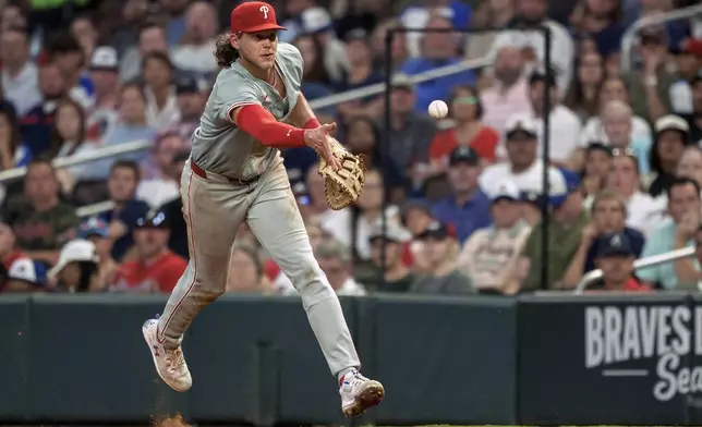 Philadelphia Phillies third baseman Alec Bohm tosses the ball to first base in the sixth inning of a baseball game against the Atlanta Braves, Friday, July 5, 2024, in Atlanta. (AP Photo/Jason Allen)