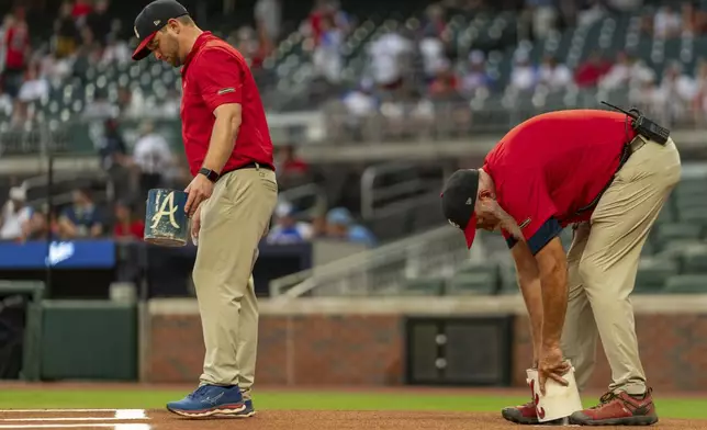 Groundskeepers prepare the field before a baseball game between the Philadelphia Phillies and the Atlanta Braves, Friday, July 5, 2024, in Atlanta. (AP Photo/Jason Allen)