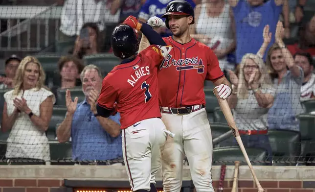 Atlanta Braves' Ozzie Albies (1) is congratulated by teammate Matt Olson, right, after hitting a home run in the sixth inning of a baseball game against the Philadelphia Phillies, Friday, July 5, 2024, in Atlanta. (AP Photo/Jason Allen)