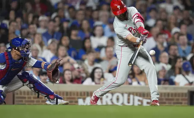 Philadelphia Phillies' Whit Merrifield hits a single during the eighth inning of a baseball game against the Chicago Cubs, Wednesday, July 3, 2024, in Chicago. (AP Photo/Erin Hooley)