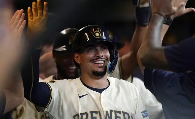 Milwaukee Brewers' Willy Adames is congratulated in the dugout after hitting a three-run home run during the eighth inning of a baseball game against the Pittsburgh Pirates, Wednesday, July 10, 2024, in Milwaukee. (AP Photo/Aaron Gash)