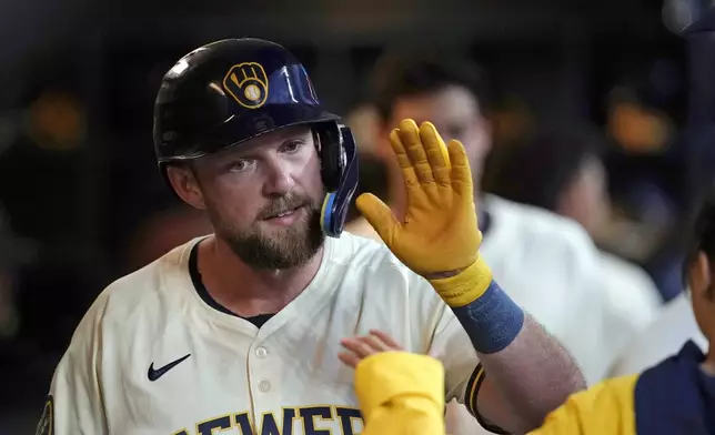 Milwaukee Brewers' Rhys Hoskins is congratulated in the dugout after hitting a solo home run during the fifth inning of a baseball game against the Pittsburgh Pirates, Wednesday, July 10, 2024, in Milwaukee. (AP Photo/Aaron Gash)