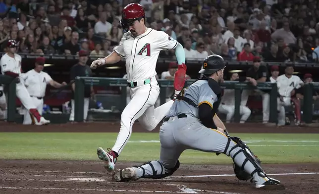 Arizona Diamondbacks' Corbin Carroll, center left, scores on a single hit by Ketel Marte in the third inning during a baseball game against the Pittsburgh Pirates, Friday, July 26, 2024, in Phoenix. (AP Photo/Rick Scuteri)