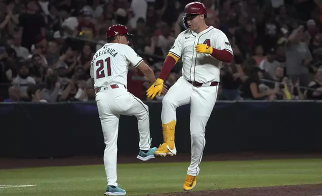 Arizona Diamondbacks' Joc Pederson celebrates with third base coach Tony Perezchica (21) after hitting a solo home run against the Pittsburgh Pirates in the sixth inning during a baseball game, Friday, July 26, 2024, in Phoenix. (AP Photo/Rick Scuteri)