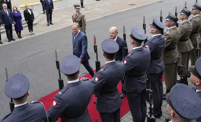 German Chancellor Olaf Scholz, center right, and Polish Prime Minister Donald Tusk review the guard of honor before German-Polish inter-governmental consultations in front of Prime Minister Chancellery in Warsaw, Poland, Tuesday, July 2, 2024. (AP Photo/Czarek Sokolowski)