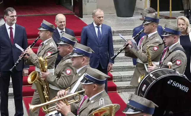 German Chancellor Olaf Scholz, center left, and Polish Prime Minister Donald Tusk, center right, review the guard of honor before German-Polish inter-governmental consultations in front of Prime Minister Chancellery in Warsaw, Poland, Tuesday, July 2, 2024. (AP Photo/Czarek Sokolowski)