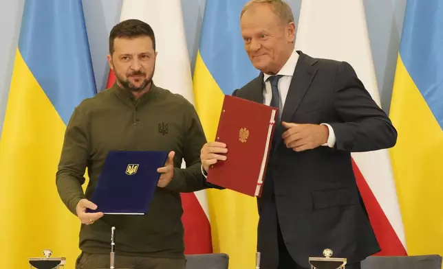 Poland's Prime Minister Donald Tusk, right, and Ukraine's President Volodymyr Zelenskyy after signing an agreement of cooperation and defense, in Warsaw, Poland, on Monday, July 8, 2024. (AP Photo/Czarek Sokolowski)