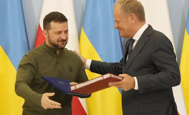 Poland's Prime Minister Donald Tusk, right, and Ukraine's President Volodymyr Zelenskyy after signing an agreement of cooperation and defense, in Warsaw, Poland, on Monday, July 8, 2024. (AP Photo/Czarek Sokolowski)