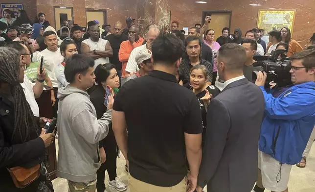 Utica Mayor Michael Galime, center right, grey jacket, talks with the family members of a 13-year-old boy who was fatally shot by a police officer Friday night after a news conference, Saturday, June 28, 2024 in Utica, N.Y. An officer shot and killed the teenager who was fleeing while wielding a “realistic appearing firearm," authorities said Saturday. (Kenny Lacy Jr./Syracuse.com via AP)