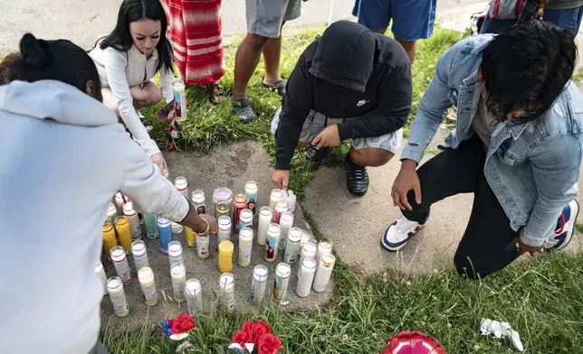 People light candles on the sidewalk during a vigil for 13-year-old Nyah Mway in Utica, N.Y., Saturday, June 29, 2024. On Friday, June 28, Mway was fatally shot by police who’d tackled him to the ground after he allegedly pointed what turned out to be a BB gun at them during a foot chase. (Daniel DeLoach/Observer-Dispatch via AP)