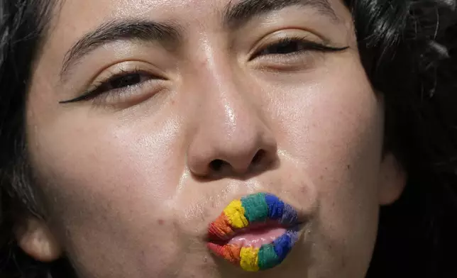 A woman with rainbow colored lips attends the annual Gay Pride Parade in Quito, Ecuador, Saturday, June 22, 2024. (AP Photo/Dolores Ochoa)
