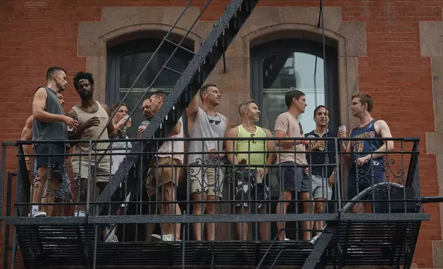 People watch the NYC Pride March from a fire escape, Sunday, June 30, 2024, in New York. (AP Photo/Andres Kudacki)