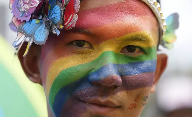 A participant with a rainbow painted on his face takes part in the Pride Parade in Bangkok, Thailand, Saturday, June 1, 2024. (AP Photo/Sakchai Lalit)