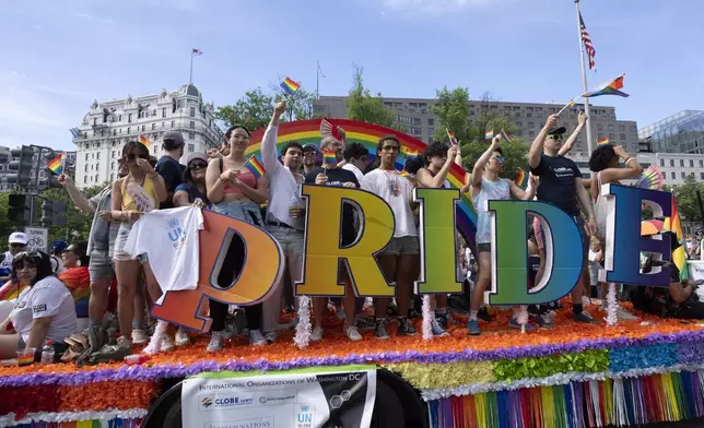 Participants of the Capital Pride Parade wave from a float during the annual celebrations of the LGBTQ+ community and supporters in Washington, Saturday, June 8, 2024. (AP Photo/Manuel Balce Ceneta)