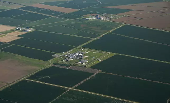 In this aerial photo, a cell block and agricultural fields on the grounds of the Louisiana State Penitentiary sit surrounded by agricultural land in Angola, La., Friday, July 21, 2023. America's largest maximum-security prison, known as Angola, sits on 18,000 acres where prisoners have toiled on the same farm lines as enslaved men and women since after emancipation often without shade, adequate work breaks or even sunscreen. In September, several incarcerated workers along with the New Orleans-based advocacy group Voice of the Experienced filed a class-action lawsuit calling for an end to the farm line, and accusing the state of cruel and unusual punishment. (AP Photo/Gerald Herbert)