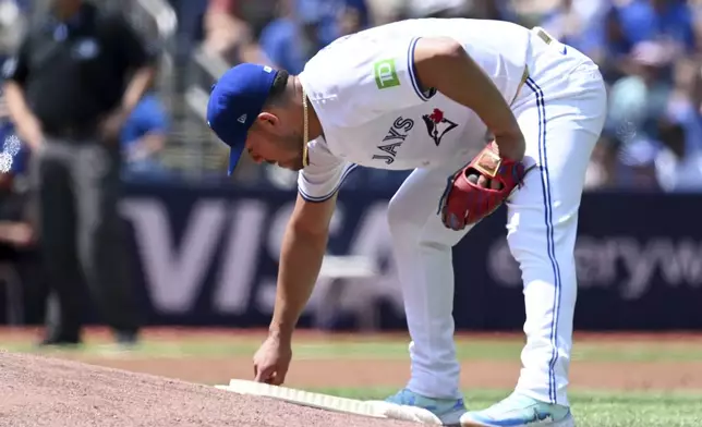 Toronto Blue Jays starting pitcher Jose Barrios writes on the mound prior to a baseball game against the Texas Rangers in Toronto, Sunday, July 28, 2024. (Jon Blacker/The Canadian Press via AP)