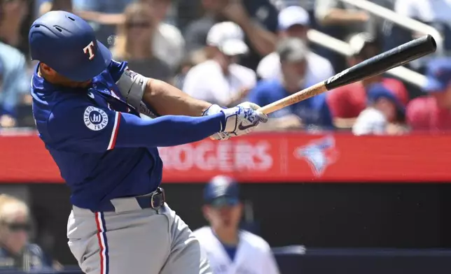 Texas Rangers' Marcus Semien hits a single against the Toronto Blue Jays in first-inning baseball game action in Toronto, Sunday, July 28, 2024. (Jon Blacker/The Canadian Press via AP)