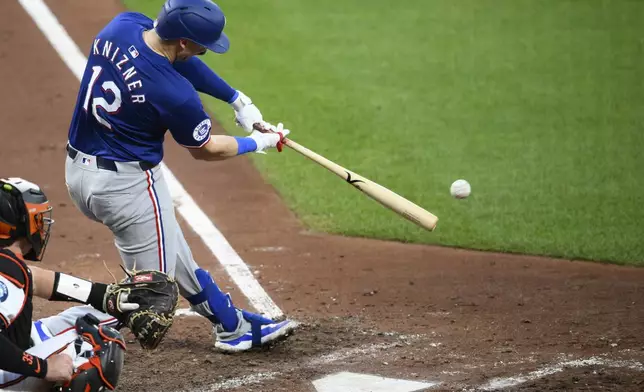 Texas Rangers' Andrew Knizner (12) singles in a run during the fourth inning of a baseball game against the Baltimore Orioles, Sunday, June 30, 2024, in Baltimore. (AP Photo/Nick Wass)