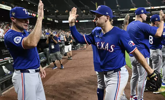 Texas Rangers' Wyatt Langford, right, celebrates after a baseball game against the Baltimore Orioles, Sunday, June 30, 2024, in Baltimore. The Rangers won 11-2. (AP Photo/Nick Wass)