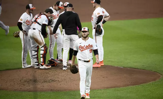 Baltimore Orioles starting pitcher Cole Irvin (19) walks back to the dugout after he was removed during the fourth inning of a baseball game against the Texas Rangers, Sunday, June 30, 2024, in Baltimore. (AP Photo/Nick Wass)