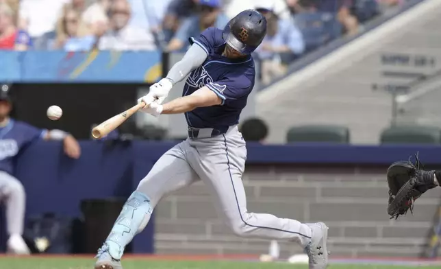 Tampa Bay Rays designated hitter Brandon Lowe hits an RBI double off Toronto Blue Jays pitcher Chris Bassitt during third-inning baseball game action in Toronto, Thursday, July 25, 2024. (Chris Young/The Canadian Press via AP)