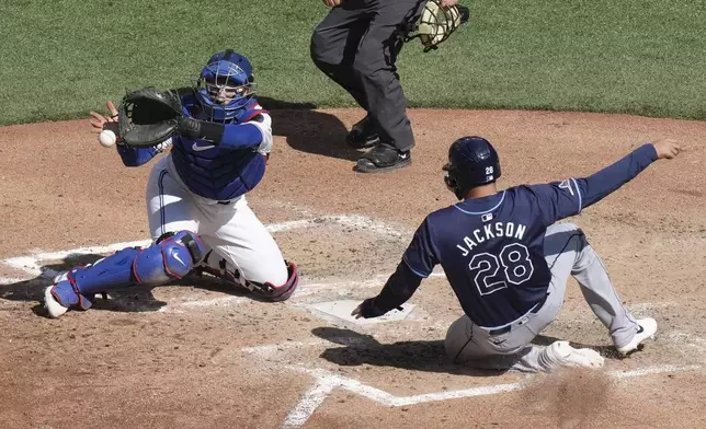 Tampa Bay Rays' Alex Jackson (28) scores ahead of a tag by Toronto Blue Jays catcher Danny Jansen during sixth-inning baseball game action in Toronto, Thursday, July 25, 2024. (Chris Young/The Canadian Press via AP)