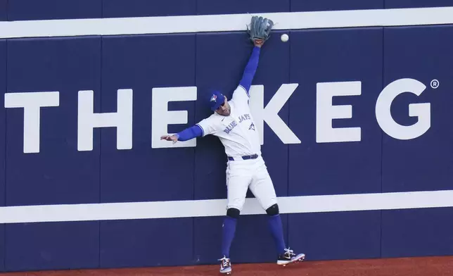 Toronto Blue Jays outfielder George Springer fails to catch a fly ball from Tampa Bay Rays' Alex Jackson against the outfield wall during seventh inning American League MLB baseball action in Toronto on Thursday, July 25, 2024. (Chris Young/The Canadian Press via AP)