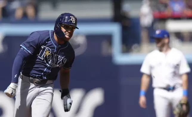 Tampa Bay Rays' Richie Palacios rounds third base to score after teammate Isaac Paredes hit an RBI double off Toronto Blue Jays pitcher Chris Bassitt during third-inning baseball game action in Toronto, Thursday, July 25, 2024. (Chris Young/The Canadian Press via AP)