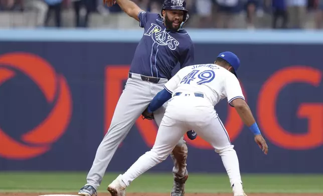 Tampa Bay Rays third base Amed Rosario (10) steals second base during second inning American League MLB baseball action against Toronto Blue Jays shortstop Leo Jiménez (49) in Toronto on Thursday, July 25, 2024. (Chris Young/The Canadian Press via AP)