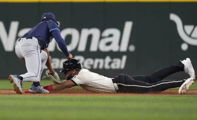 Texas Rangers Leody Taveras, right, is tagged out while trying to steal second base against Tampa Bay Rays infielder Richie Palacios, left, during the third inning of a baseball game in Arlington, Texas, Friday, July 5, 2024. (AP Photo/LM Otero)