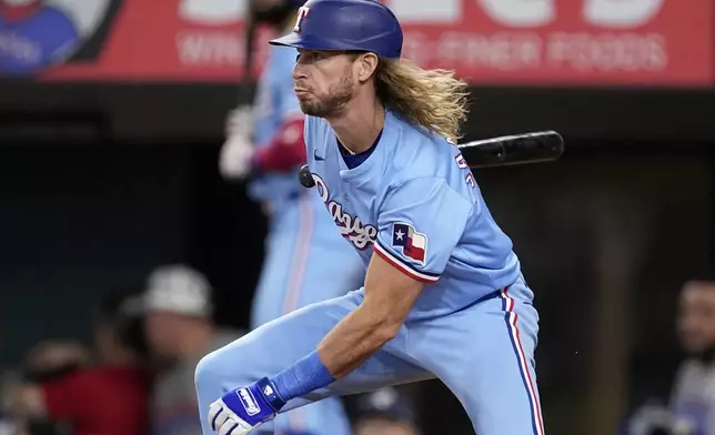 Texas Rangers' Travis Jankowski follows through on a two-run single against the Tampa Bay Rays in the fourth inning of a baseball game in Arlington, Texas, Sunday, July 7, 2024. Rangers' Nathaniel Lowe and Jonah Heim scored on the hit. (AP Photo/Tony Gutierrez)